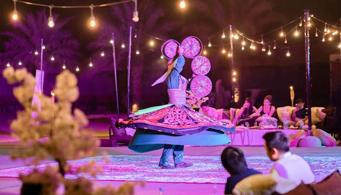 Traditional dancer spinning at Dubai safari night experience.