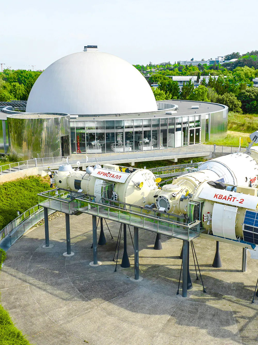 Spacecraft exhibit at Cité de l’Espace, Toulouse, France with a domed building in the background.