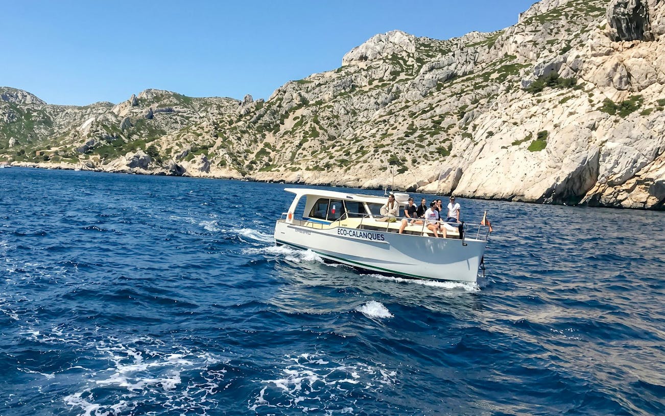 Excursion boat with tourists cruising in Calanques de Cassis, France.
