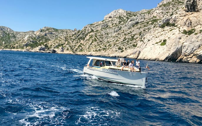 Excursion boat with tourists cruising in Calanques de Cassis, France.
