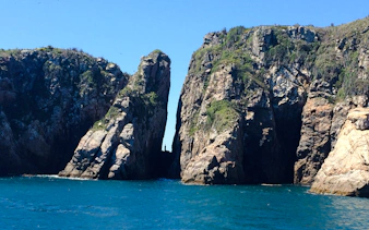 Rock formations at Arraial do Cabo, Brazil, with clear blue ocean.