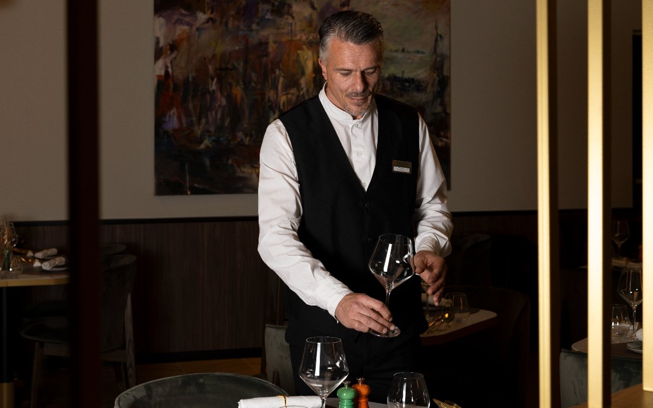 Waiter polishing wine glasses at Plaza Premium First lounge, Fiumicino Airport Terminal 1.