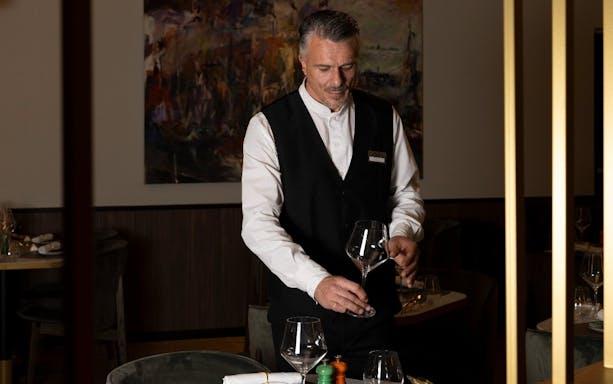 Waiter polishing wine glasses at Plaza Premium First lounge, Fiumicino Airport Terminal 1.