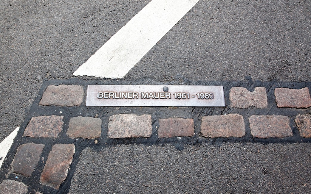 Berlin Wall marker on pavement, indicating historical site from 1961 to 1989.