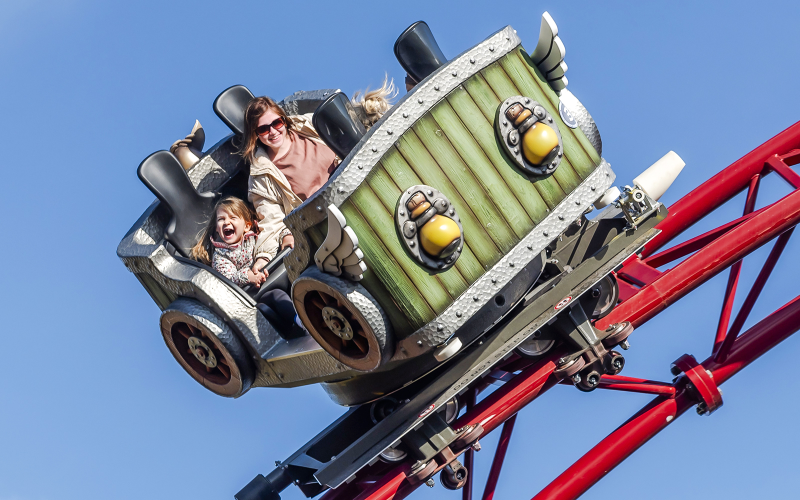 Family enjoying a roller coaster ride at Parc Asterix during Christmas celebrations.