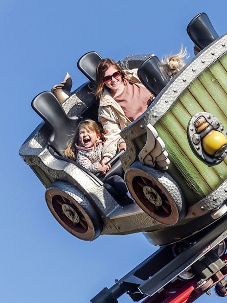 Family enjoying a roller coaster ride at Parc Asterix during Christmas celebrations.