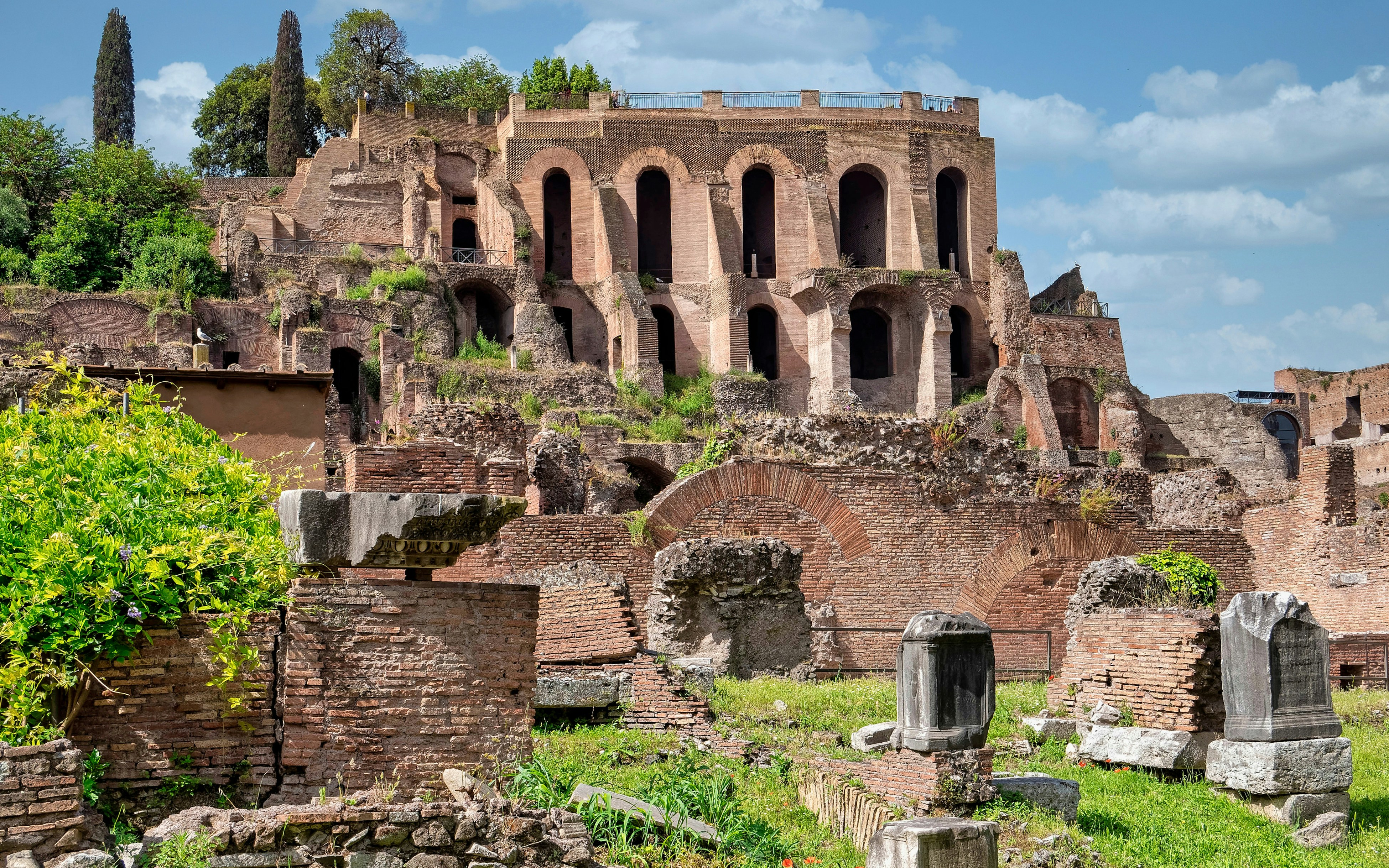 Domus Tiberiana ruins in the Roman Forum, showcasing ancient brick arches and stone structures.