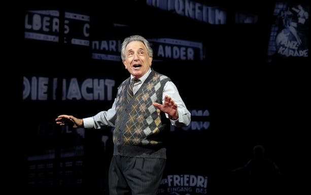 Performer on stage during "Harmony: A New Musical" with vintage backdrop.