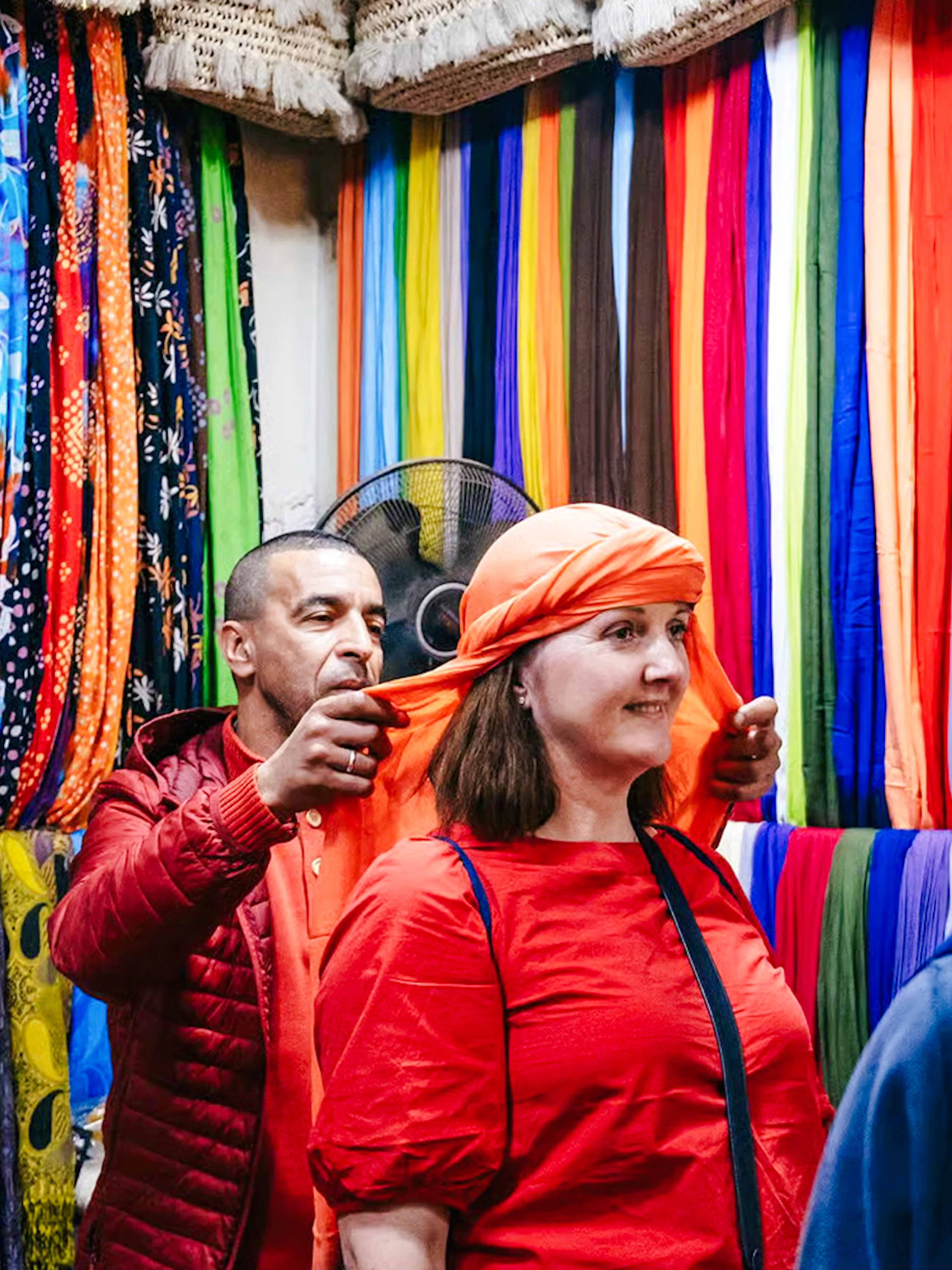 Shopper trying on headscarf in Marrakech souk during private shopping tour.