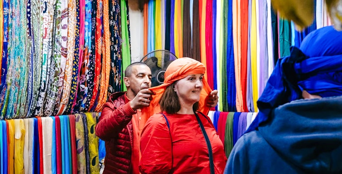 Shopper trying on headscarf in Marrakech souk during private shopping tour.