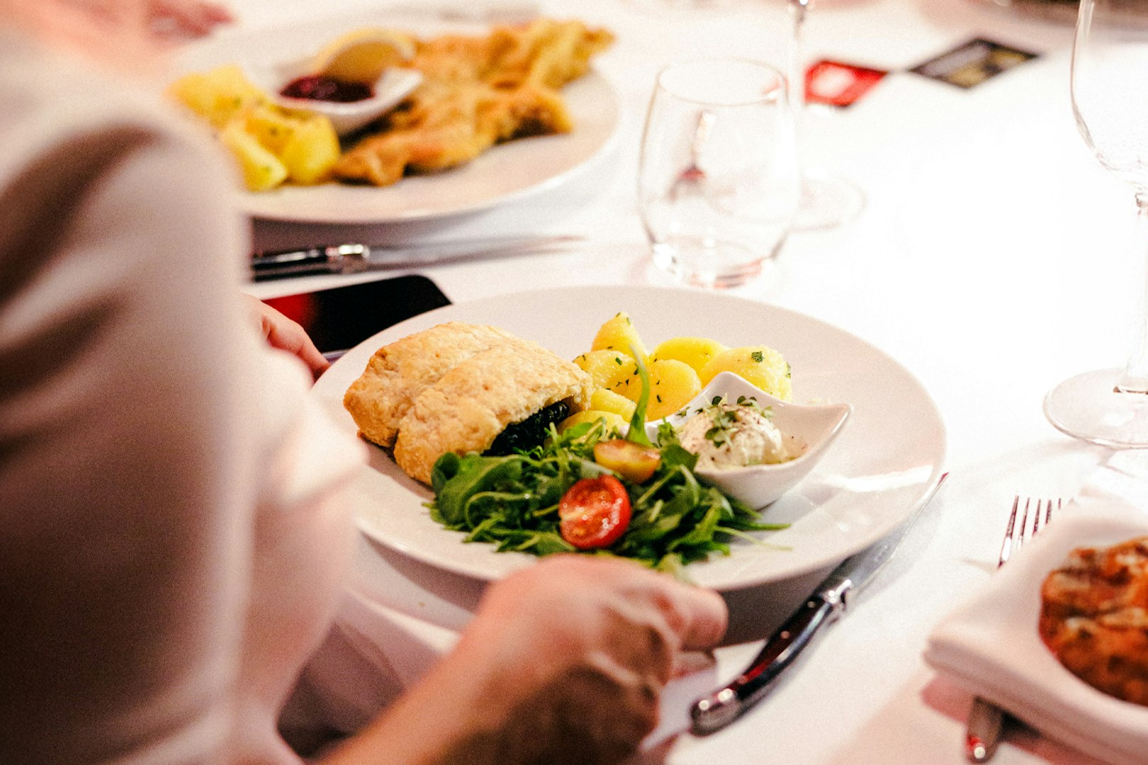 Plate with pastry, potatoes, salad, and sauce at Mirage dinner, Prater Vienna.