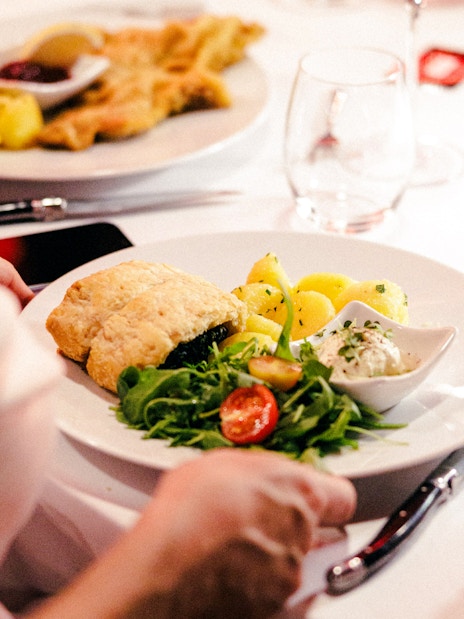 Plate with pastry, potatoes, salad, and sauce at Mirage dinner, Prater Vienna.