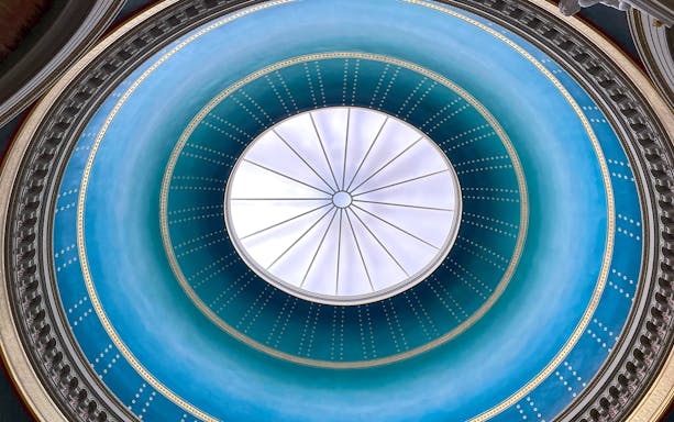 Dome ceiling of Alte Nationalgalerie in Berlin with intricate blue and gold design.