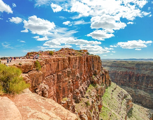 view point of Grand Canyon West with airplane flying over rugged canyon landscape.