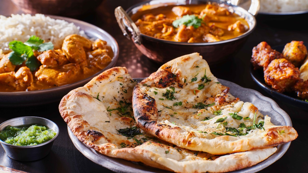 Traditional Indian cuisine with various dishes and spices displayed on a table.