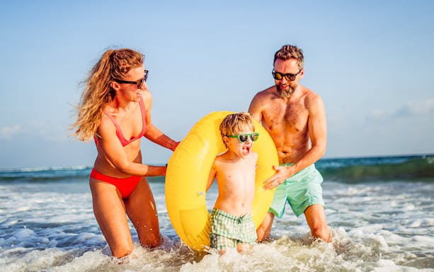 Family enjoying beach time during Favignana boat tour with wine tasting.
