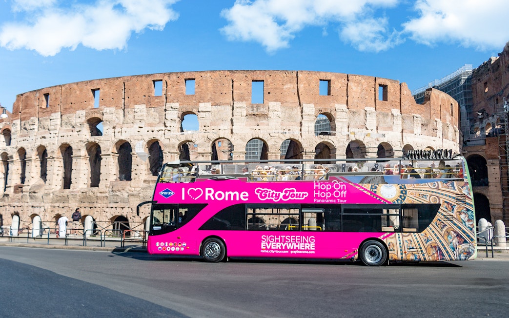 Open-top tour bus in front of the Colosseum, Rome, for I Love Rome Hop-On Hop-Off Tour.