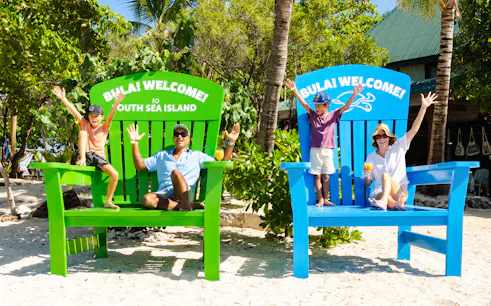 Family enjoying oversized chairs at South Sea Island, Fiji.