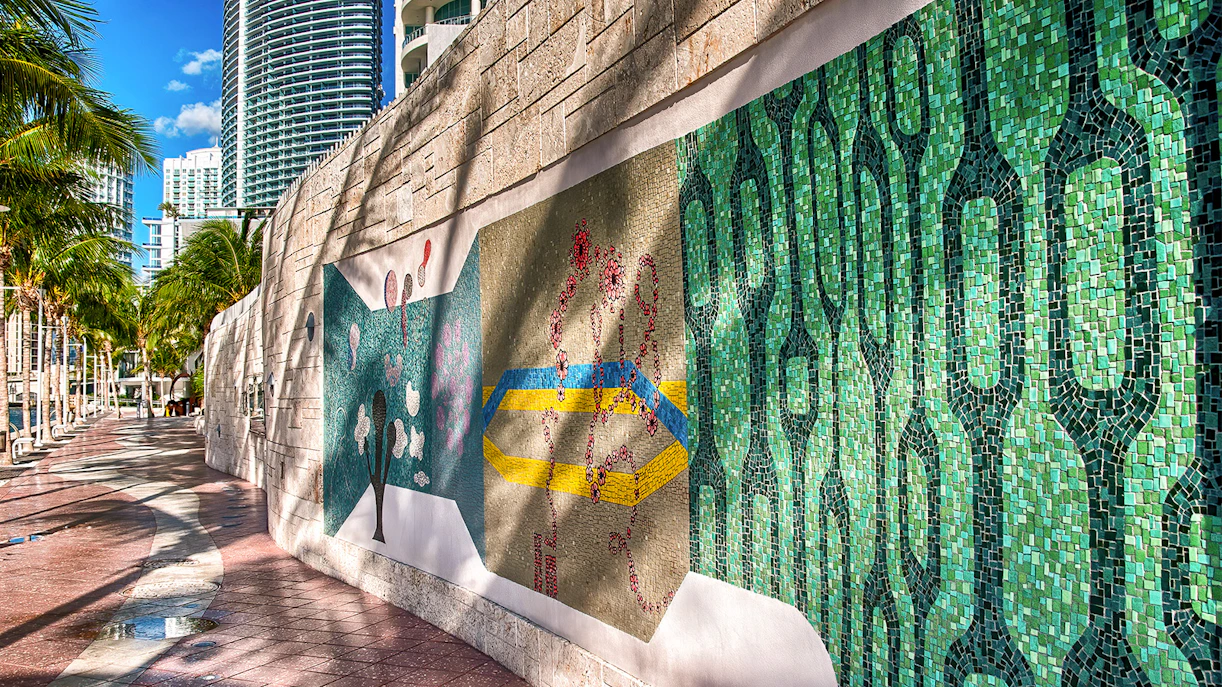 Wynwood Walls mural with colorful patterns in Miami, featuring palm trees and skyscrapers.