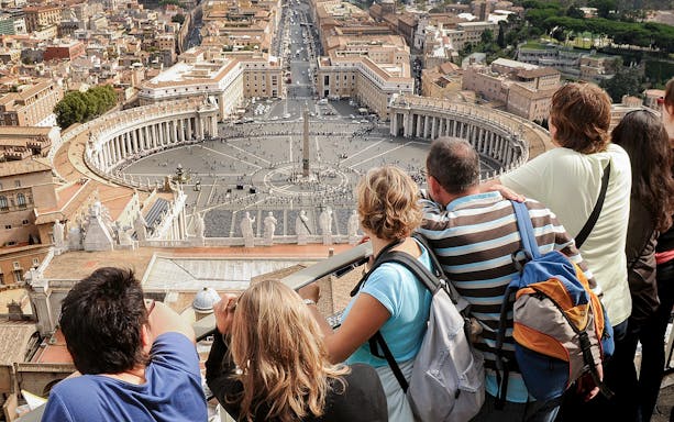 Visitors overlooking St. Peter’s Square from the Basilica Dome Terrace in Vatican City.