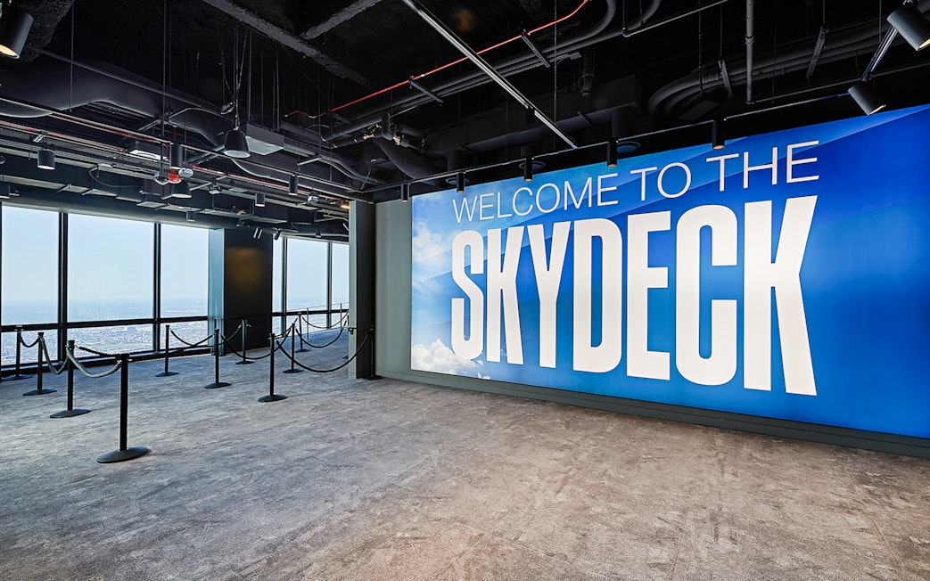 Skydeck entrance at Willis Tower, Chicago with city view through windows.