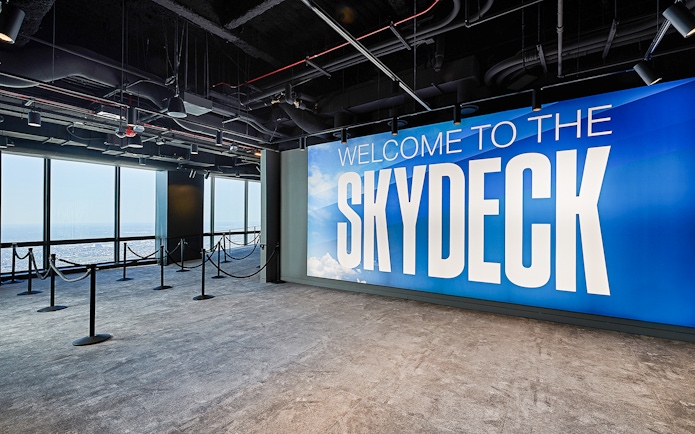 Skydeck entrance at Willis Tower, Chicago with city view through windows.