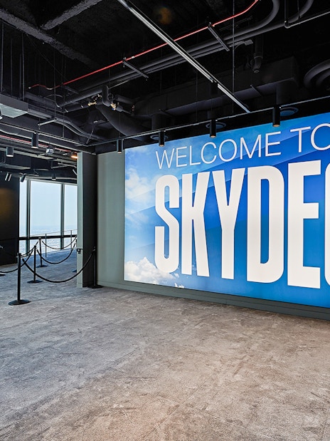 Skydeck entrance at Willis Tower, Chicago with city view through windows.