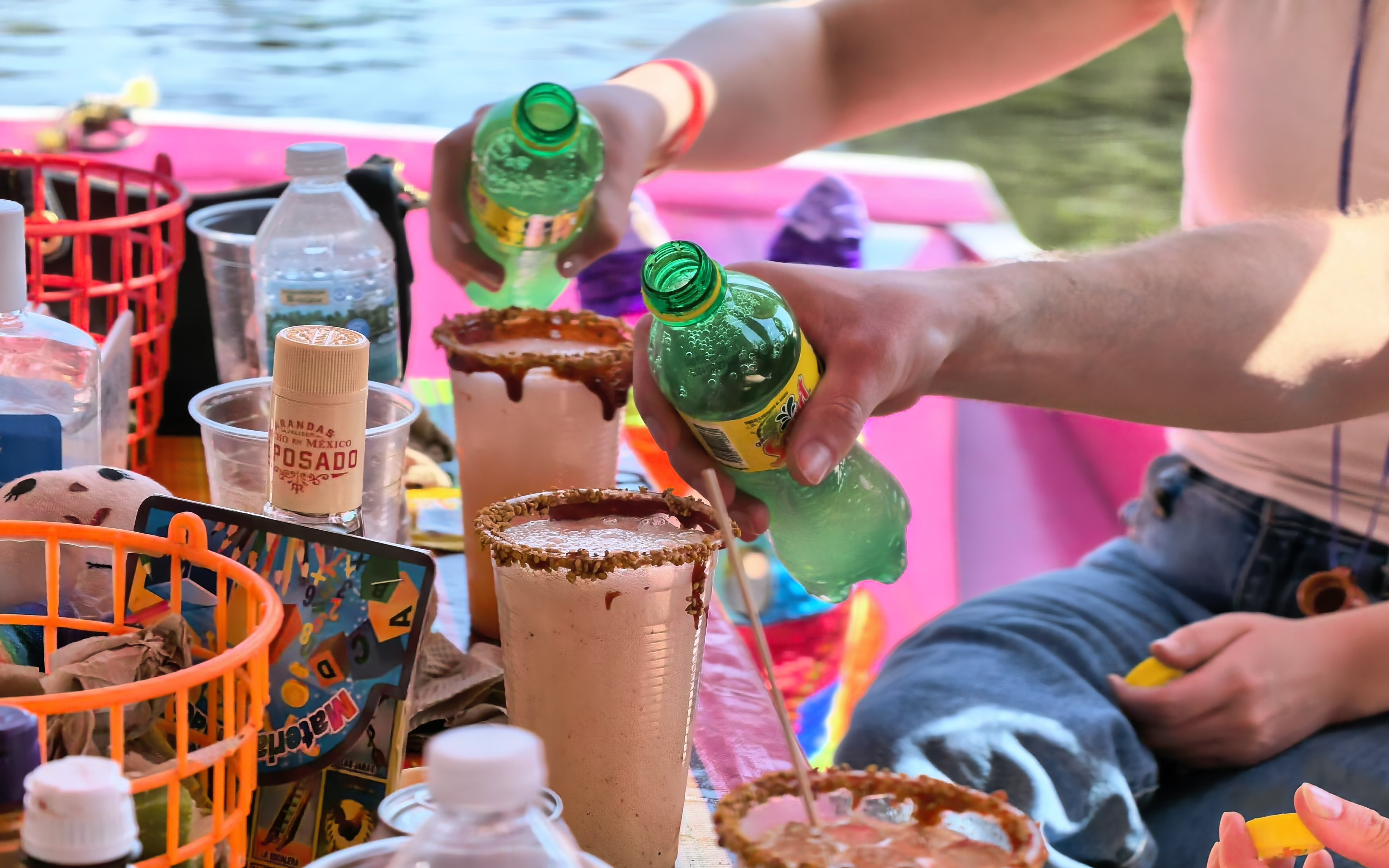 Pouring drinks on a colorful boat during Aztec Canals Cultural Experience in Mexico.