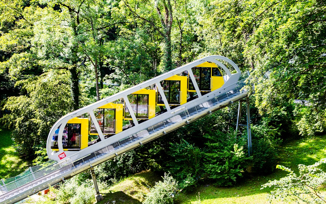Hungerburg Funicular ascending through lush green forest in Innsbruck, Austria.