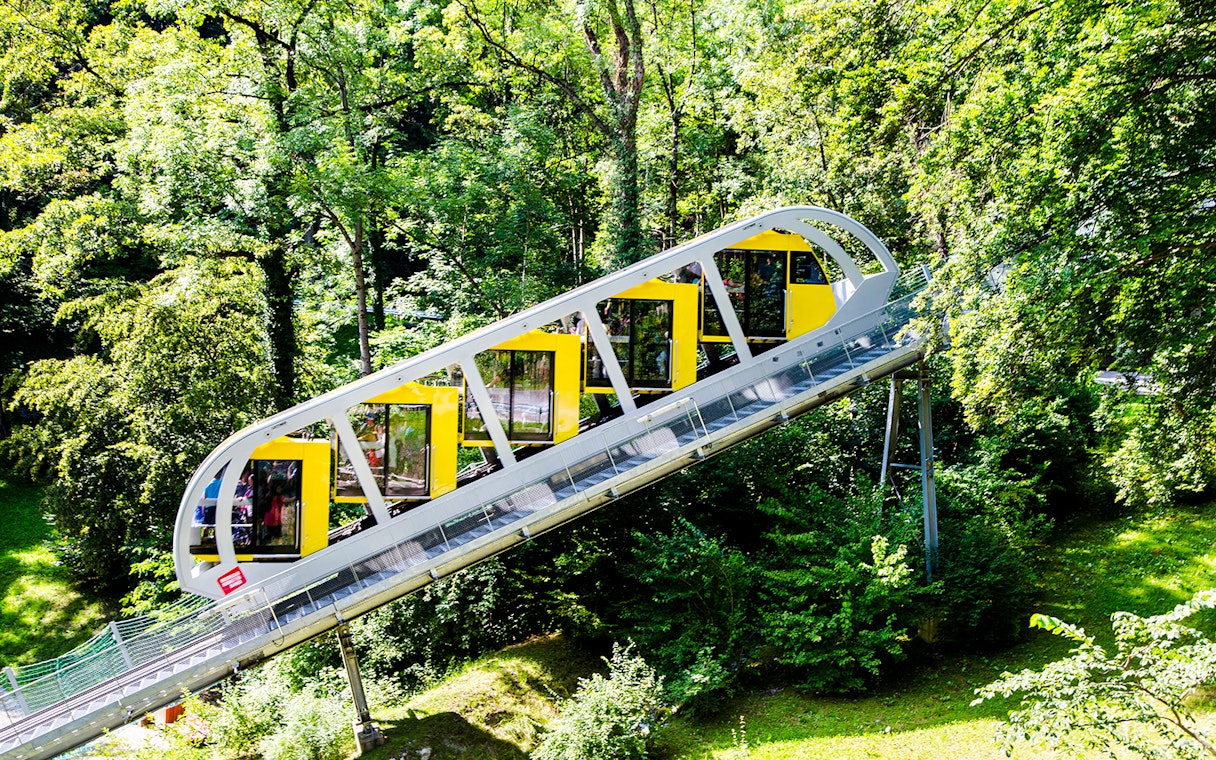 Hungerburg Funicular ascending through lush green forest in Innsbruck, Austria.