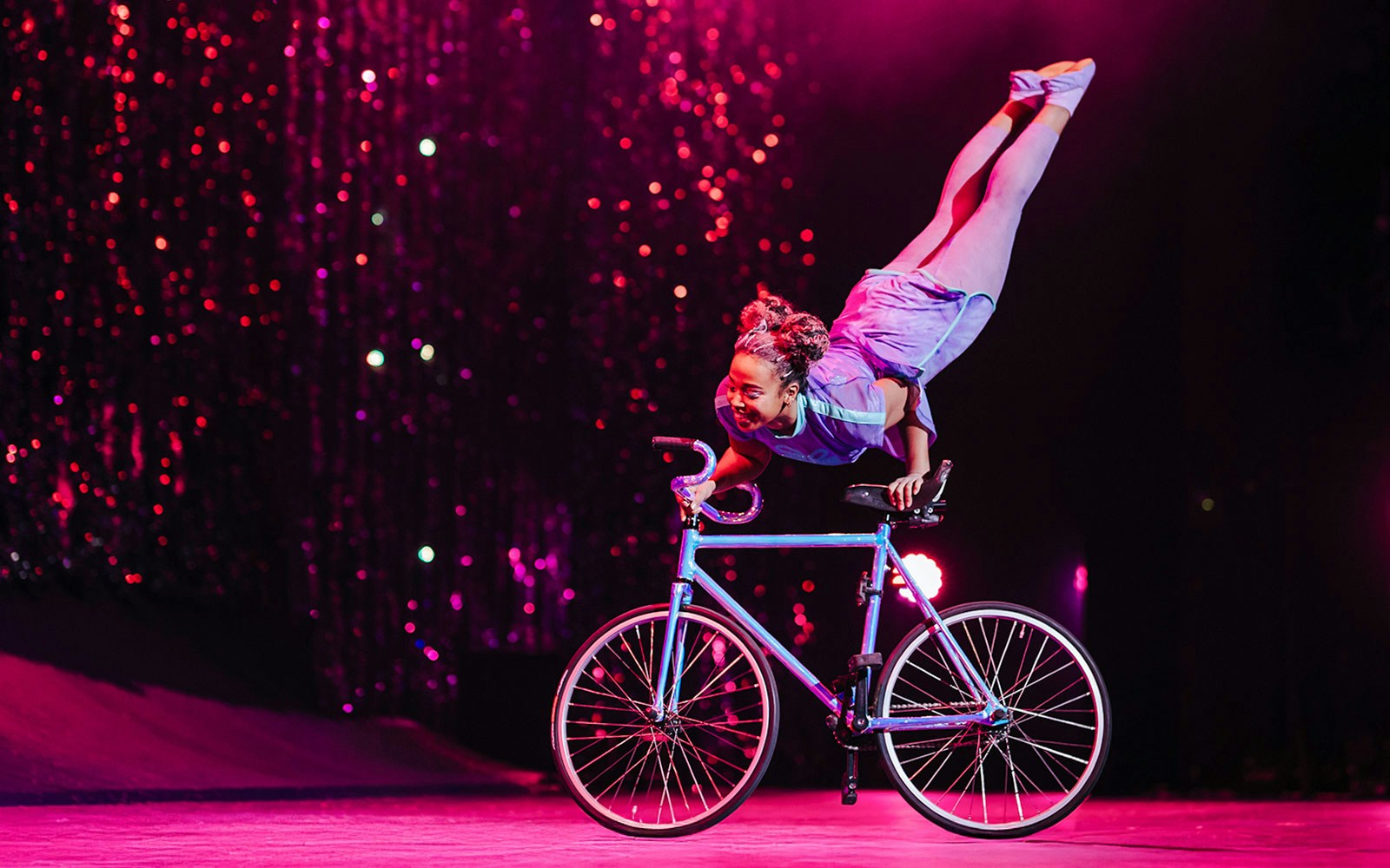 Performer balancing on a bicycle during Cirque du Soleil's 'Twas The Night Before stage show.