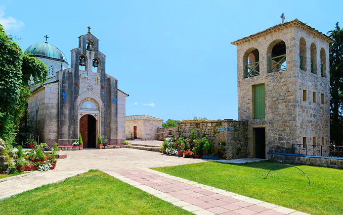Tvrdos Monastery courtyard with stone church and bell tower, Bosnia and Herzegovina.