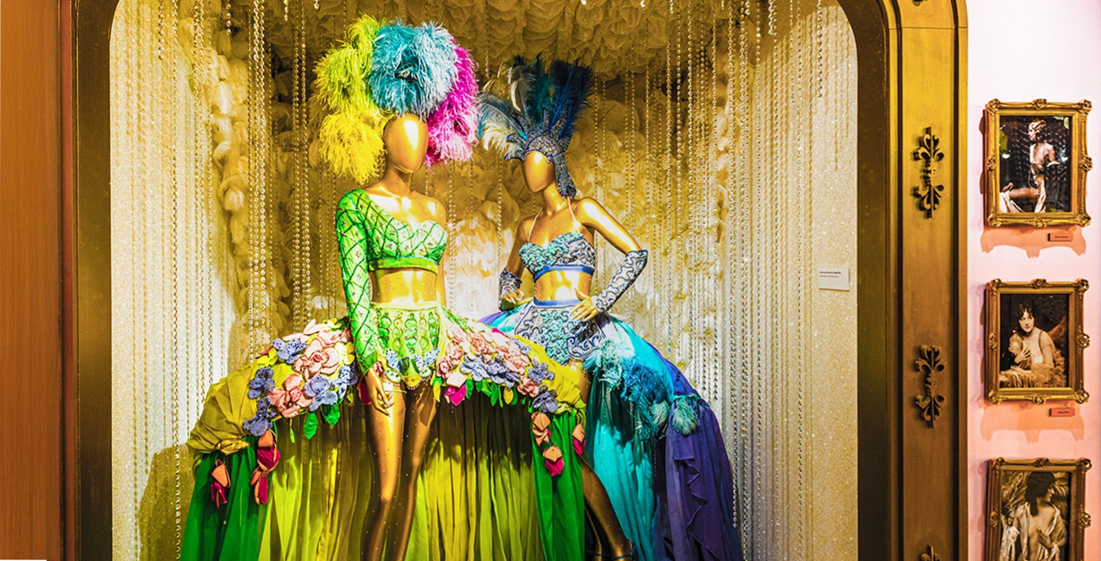 Mannequins in vibrant Broadway costumes at the Museum of Broadway exhibit.