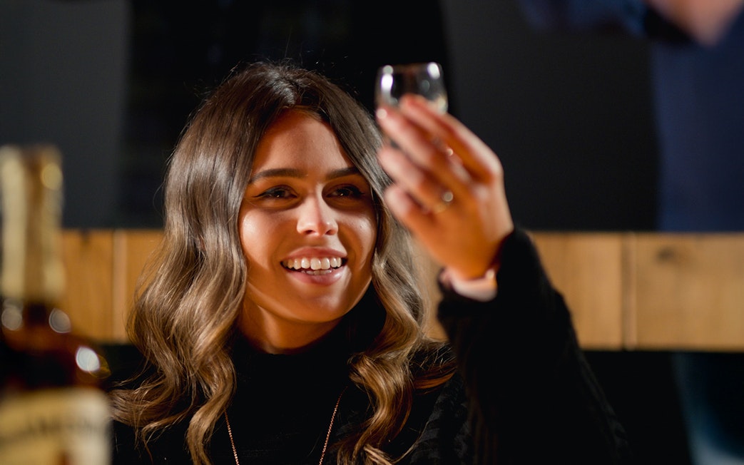 Woman enjoying whiskey tasting at Jameson Distillery tour.