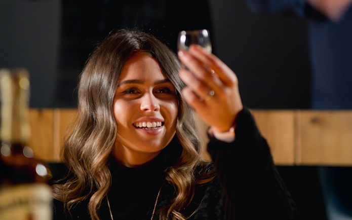 Woman enjoying whiskey tasting at Jameson Distillery tour.