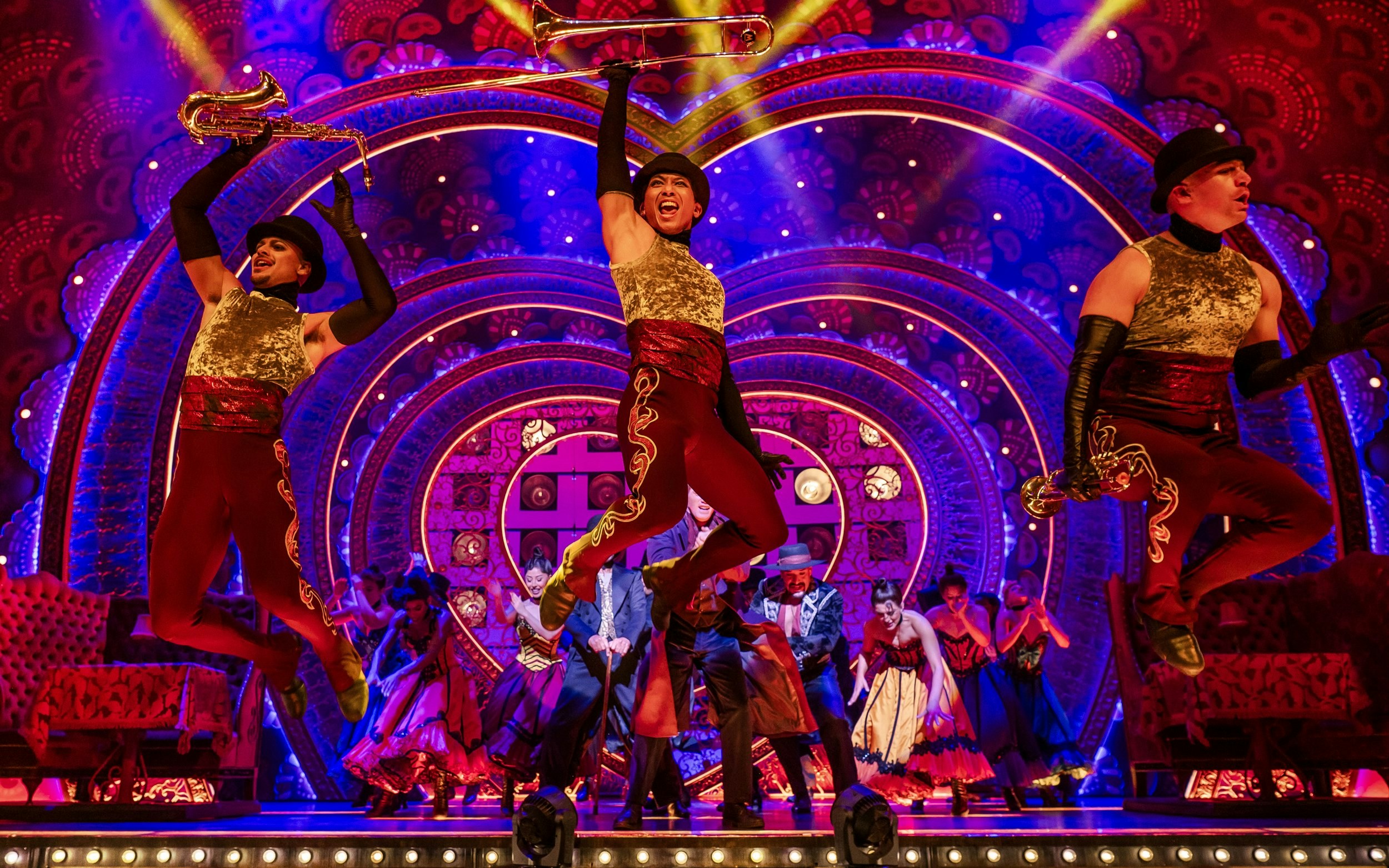 Performers in vibrant costumes on stage during Come Alive Westend show.