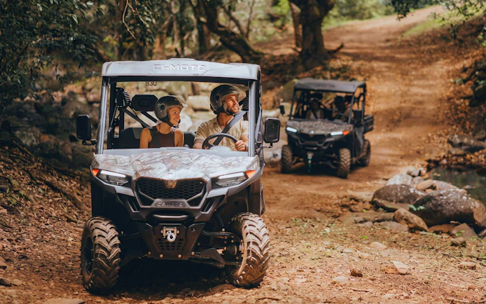 Two buggies driving through a forest trail on a Bel Ombre buggy tour.
