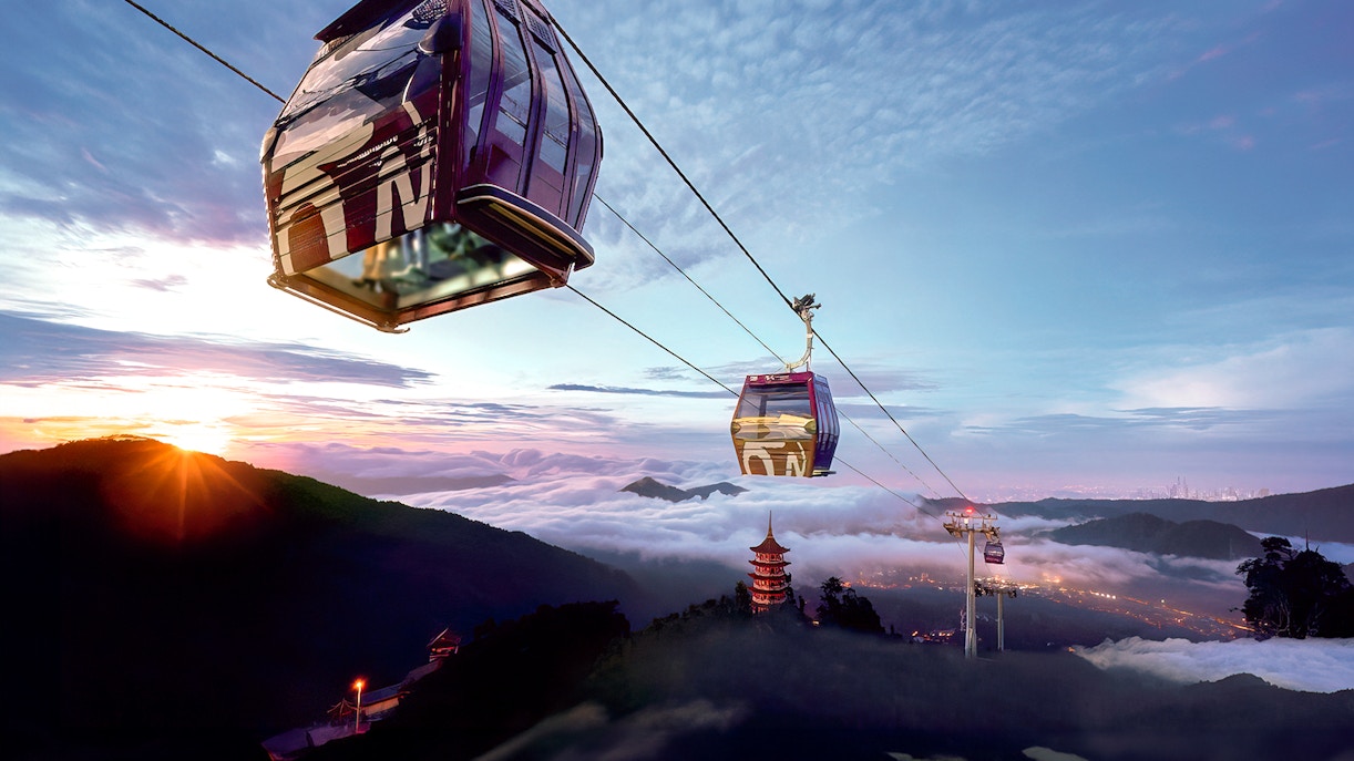 Genting Awana SkyWay cable car over misty mountains at sunrise.