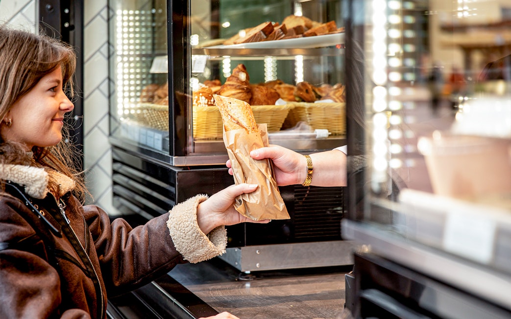 Customer receiving a pastry at Rosalie’s Snack & Go counter.
