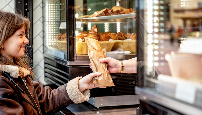 Customer receiving a pastry at Rosalie’s Snack & Go counter.