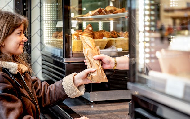 Customer receiving a pastry at Rosalie’s Snack & Go counter.