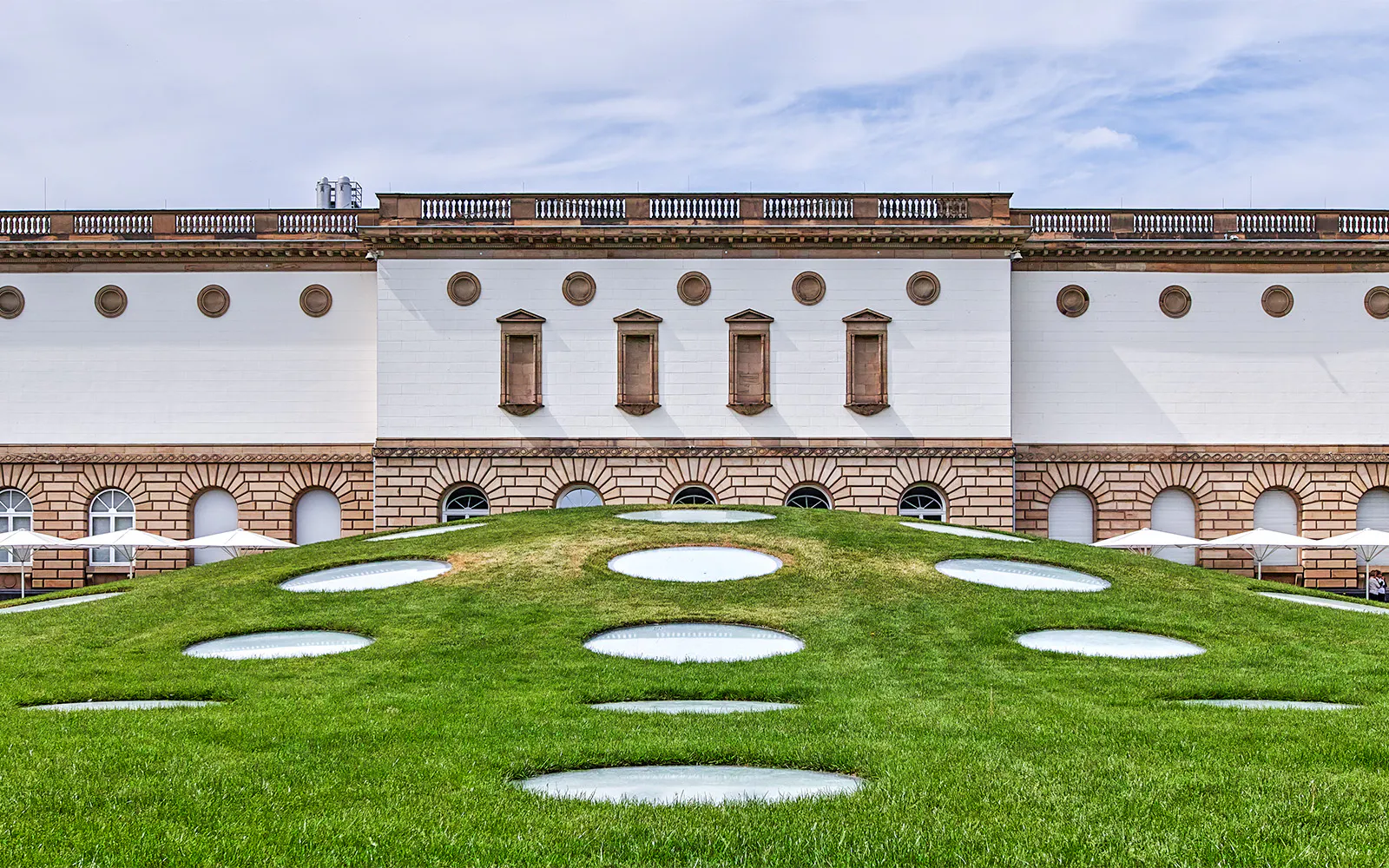 Frankfurt museum building with unique circular skylights on grassy hill.