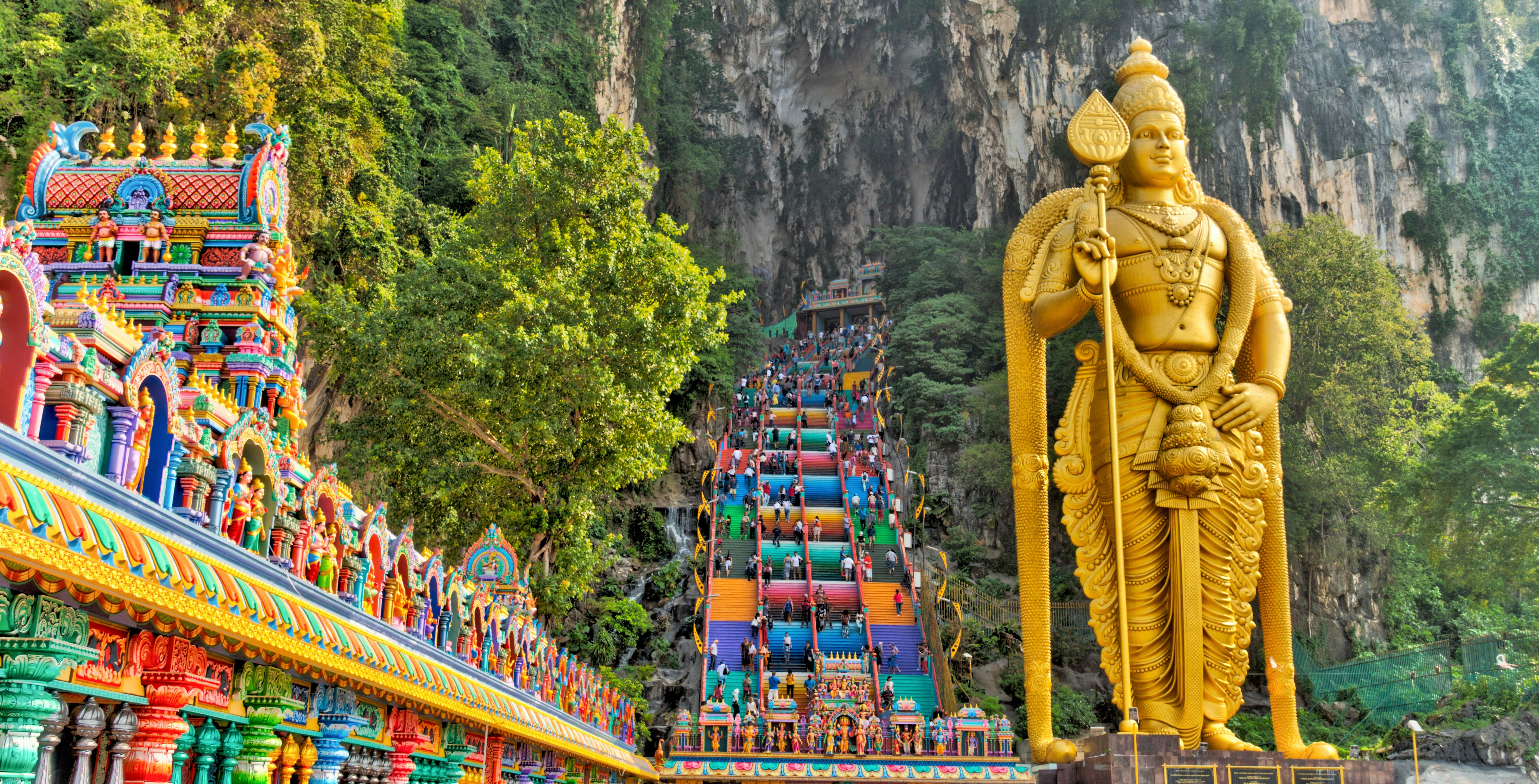 Golden statue and colorful temple steps at Batu Caves, Malaysia.