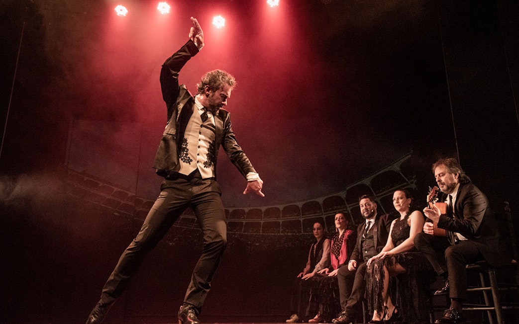 Flamenco dancer performing on stage with musicians at Teatro Flamenco Barcelona.