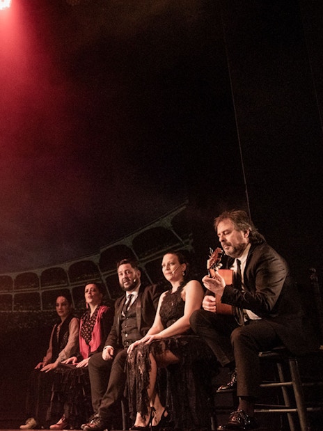 Flamenco dancer performing on stage with musicians at Teatro Flamenco Barcelona.