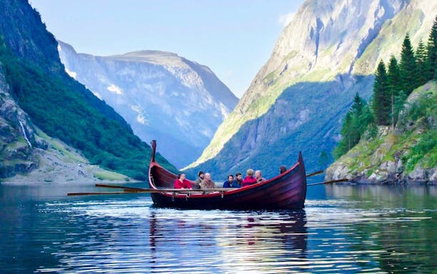 Boat cruise on Nærøyfjord with passengers surrounded by steep mountains.