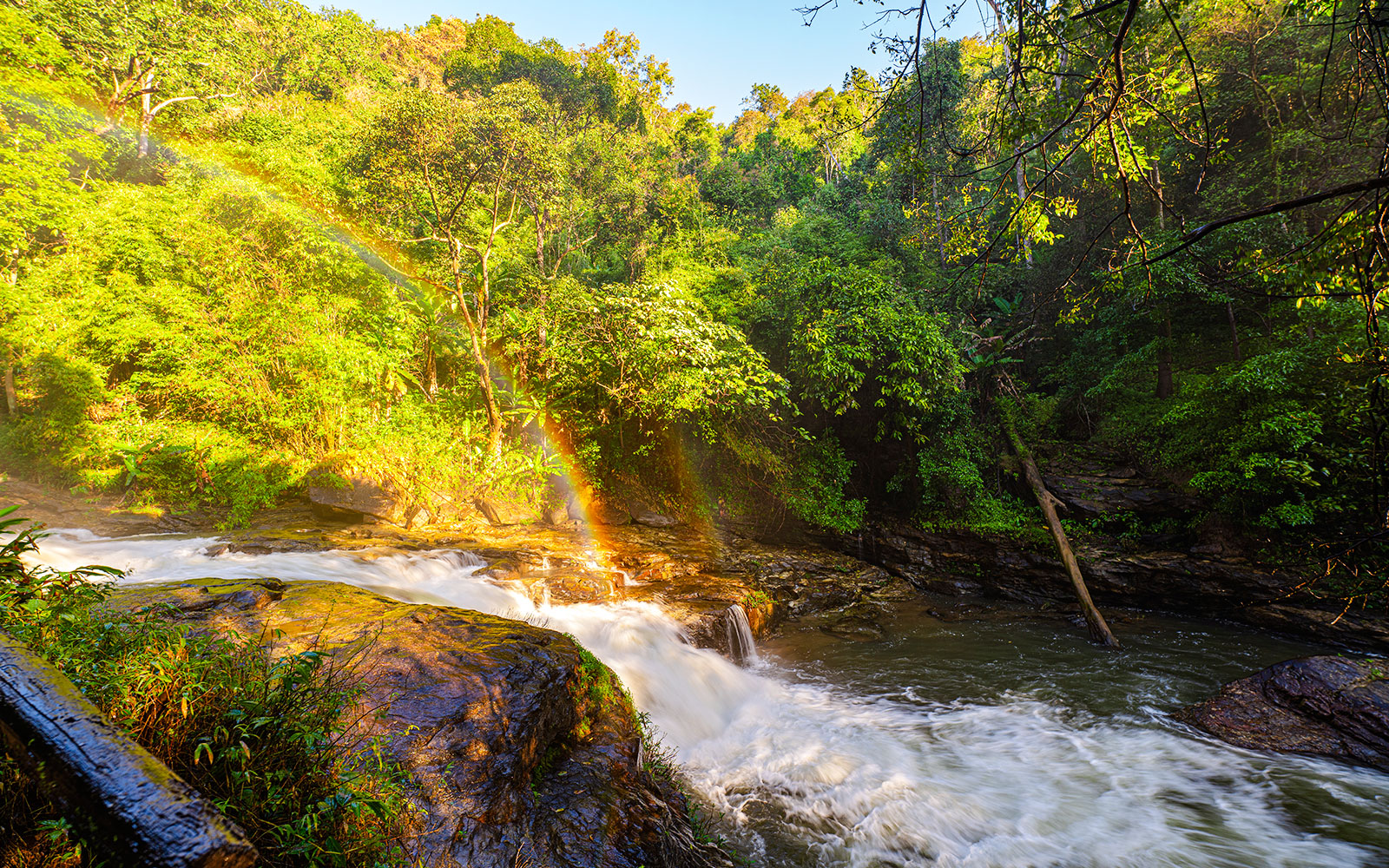 Waterfall with rainbow in lush forest at Doi Inthanon, Chiang Mai.