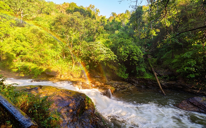 Waterfall with rainbow in lush forest at Doi Inthanon, Chiang Mai.