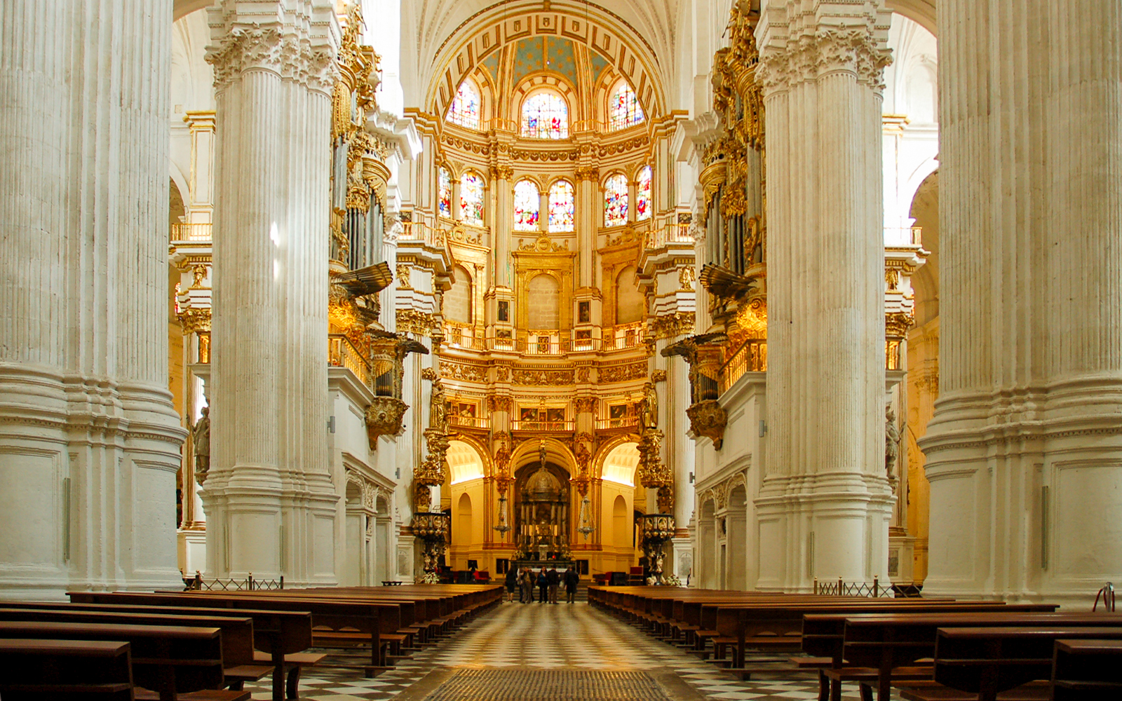 Interior view of the Royal Chapel of Granada with ornate columns and stained glass windows.
