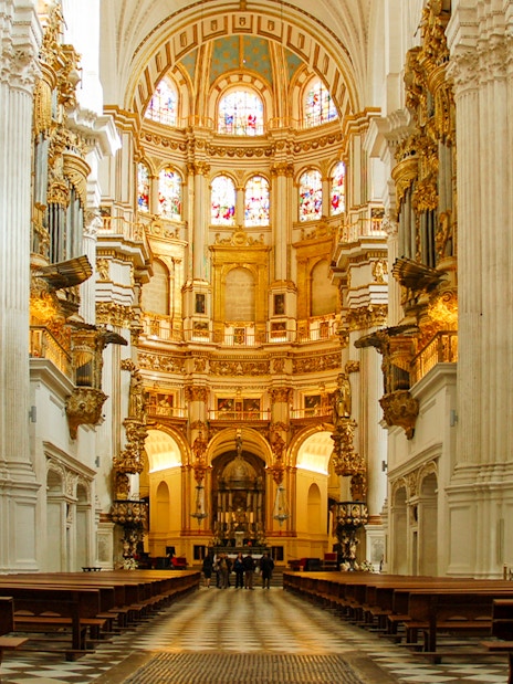 Interior view of the Royal Chapel of Granada with ornate columns and stained glass windows.